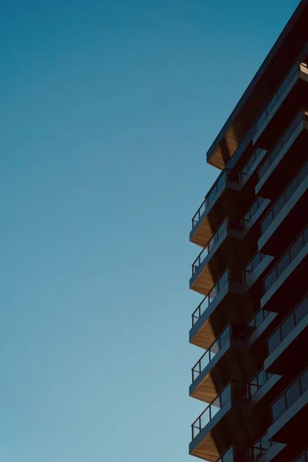 High-rise glass facade with suspended platform for window cleaning.